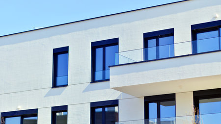 Modern architecture of urban residential apartment buildings on a sunny day. Low-rise apartment buildings with large windows and extensive terraces. White facade of a modern apartmentの写真素材