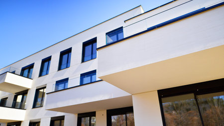 Modern architecture of urban residential apartment buildings on a sunny day. Low-rise apartment buildings with large windows and extensive terraces. White facade of a modern apartmentの写真素材