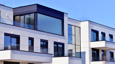 Modern architecture of urban residential apartment buildings on a sunny day. Low-rise apartment buildings with large windows and extensive terraces. White facade of a modern apartmentの写真素材