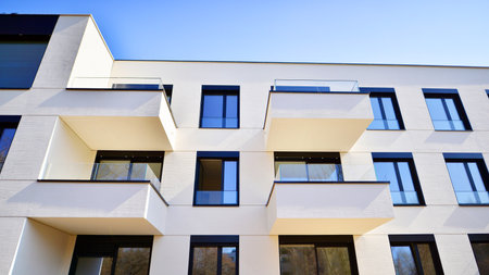 Modern architecture of urban residential apartment buildings on a sunny day. Low-rise apartment buildings with large windows and extensive terraces. White facade of a modern apartmentの写真素材