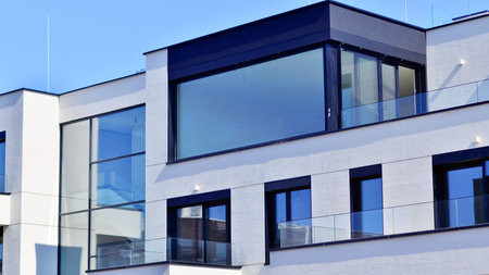 Modern architecture of urban residential apartment buildings on a sunny day. Low-rise apartment buildings with large windows and extensive terraces. White facade of a modern apartmentの写真素材