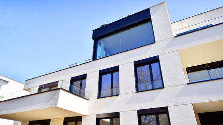 Modern architecture of urban residential apartment buildings on a sunny day. Low-rise apartment buildings with large windows and extensive terraces. White facade of a modern apartmentの写真素材