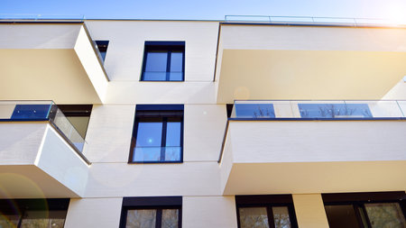 Modern architecture of urban residential apartment buildings on a sunny day. Low-rise apartment buildings with large windows and extensive terraces. White facade of a modern apartmentの写真素材