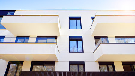 Modern architecture of urban residential apartment buildings on a sunny day. Low-rise apartment buildings with large windows and extensive terraces. White facade of a modern apartmentの写真素材