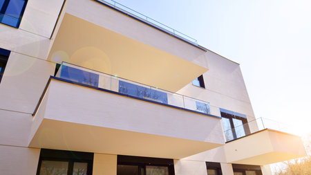 Modern architecture of urban residential apartment buildings on a sunny day. Low-rise apartment buildings with large windows and extensive terraces. White facade of a modern apartmentの写真素材