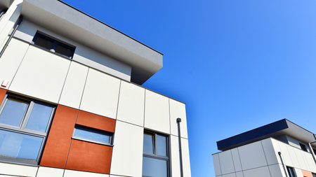 Terraced family homes in newly developed housing estate. The real estate market in the suburbs. New single family houses in a new development area. Residential homes with modern faの写真素材