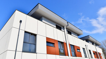 Terraced family homes in newly developed housing estate. The real estate market in the suburbs. New single family houses in a new development area. Residential homes with modern faの写真素材