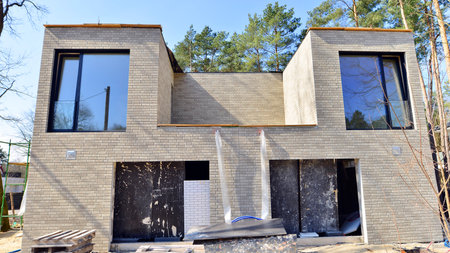 A suburban district of single-family homes. Single family house construction site. Modern designed single-family house under construction.の写真素材