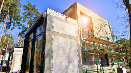 A suburban district of single-family homes. Single family house construction site. Modern designed single-family house under construction.の写真素材