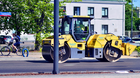 Warsaw, Poland. April 26, 2025. Roadworks and process of asphalting. Blacktopping and paving new...