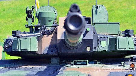 Heavy military tank vehicle turret gun aiming on a target and ready to fire. The rotating turret...