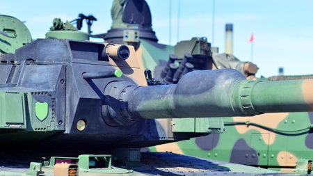Heavy military tank vehicle turret gun aiming on a target and ready to fire. The rotating turret...