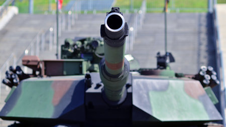 Heavy military tank vehicle turret gun aiming on a target and ready to fire. The rotating turret...