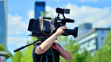 Video camera operator working with his equipment at event.