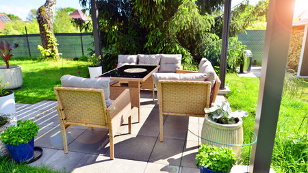 Modern aluminum pergola with stylish garden furniture in a beautiful garden.