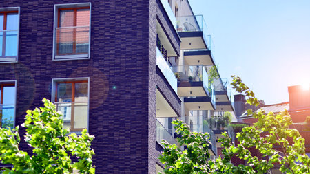 New modern block of flats in green area. complex. New modern block of flats in green area. European residential architecture harmonizing with nature. Eco-friendly living in city wiの写真素材
