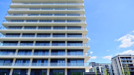 Exterior of a high modern multi-story apartment building - facade, windows and balconies.