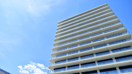 Exterior of a high modern multi-story apartment building - facade, windows and balconies.
