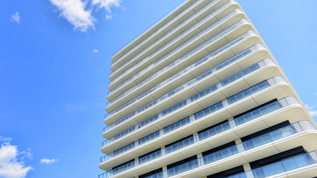 Exterior of a high modern multi-story apartment building - facade, windows and balconies.