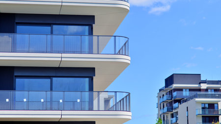 Exterior of a high modern multi-story apartment building - facade, windows and balconies. Modern glass balcony railings.の写真素材