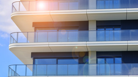 Exterior of a high modern multi-story apartment building - facade, windows and balconies. Modern glass balcony railings.の写真素材