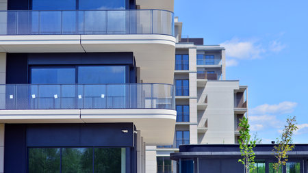 Exterior of a high modern multi-story apartment building - facade, windows and balconies. Modern glass balcony railings.の写真素材