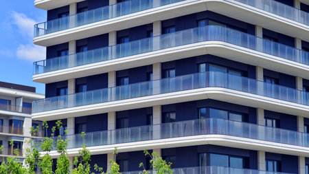 Exterior of a high modern multi-story apartment building - facade, windows and balconies. Modern glass balcony railings.の写真素材