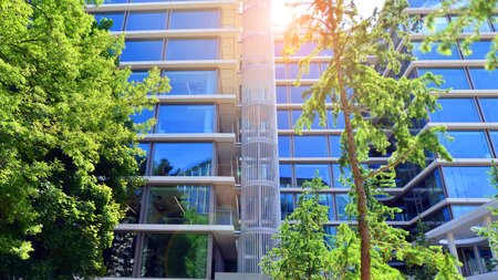 Sustainable glass office building with trees for reducing carbon dioxide. Eco-friendly building in modern city. Office with green environment. Corporate building reduce CO2.の写真素材