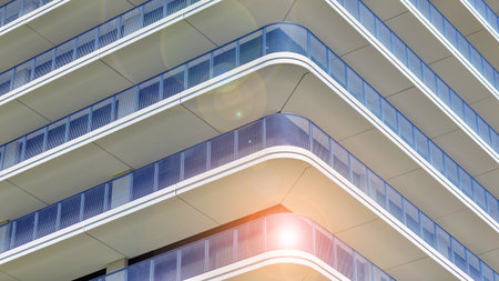 Exterior of a high modern multi-story apartment building - facade, windows and balconies. Modern glass balcony railings.の写真素材