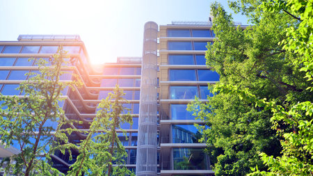 Sustainable glass office building with trees for reducing carbon dioxide. Eco-friendly building in modern city. Office with green environment. Corporate building reduce CO2.の写真素材