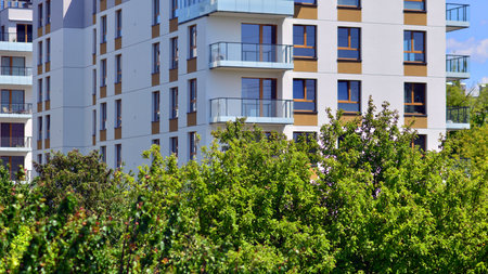European residential architecture harmonizing with nature. Eco-friendly living in city with greens. Eco apartment building saving energy and fresh air concept.の写真素材