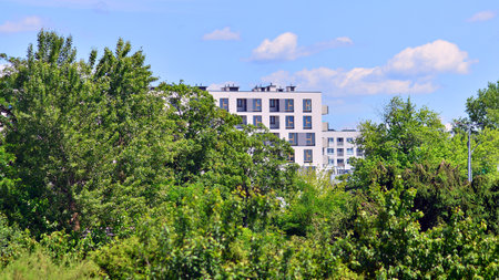 European residential architecture harmonizing with nature. Eco-friendly living in city with greens. Eco apartment building saving energy and fresh air concept.の写真素材