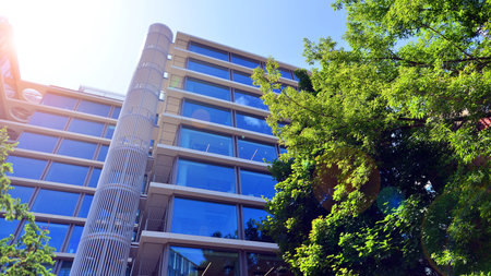 Sustainable glass office building with trees for reducing carbon dioxide. Eco-friendly building in modern city. Office with green environment. Corporate building reduce CO2.の写真素材