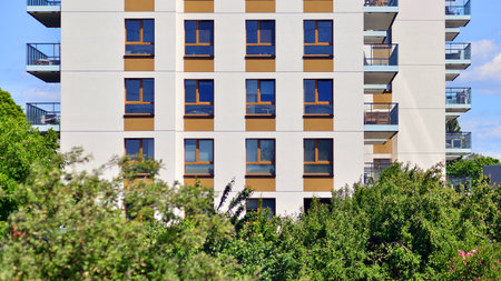 European residential architecture harmonizing with nature. Eco-friendly living in city with greens. Eco apartment building saving energy and fresh air concept.の写真素材