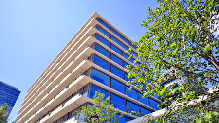 Office with green environment. Corporate building reduce CO2. Sustainable glass office building with trees for reducing carbon dioxide. Eco-friendly building in modern city.の写真素材