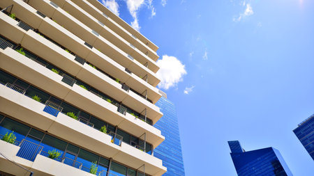 Modern office building with glass facade. Transparent glass wall of office building. Reflection of the blue sky on the facade of the building.の写真素材