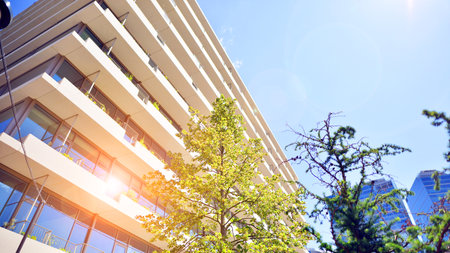 Office with green environment. Corporate building reduce CO2. Sustainable glass office building with trees for reducing carbon dioxide. Eco-friendly building in modern city.の写真素材