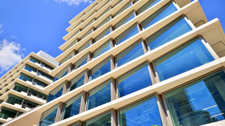 Modern office building with glass facade. Transparent glass wall of office building. Reflection of...