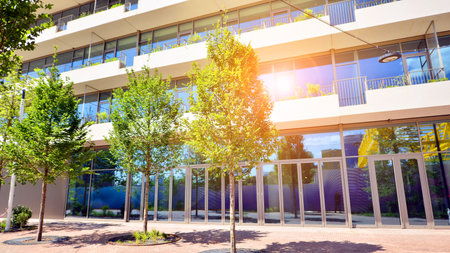 Office with green environment. Corporate building reduce CO2. Sustainable glass office building with trees for reducing carbon dioxide. Eco-friendly building in modern city.の写真素材