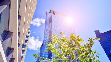 City life, urban landscape and ecology. Modern office complex with glass facades and smooth lines against backdrop of green trees, concept of modern architecture. Organically builtの写真素材