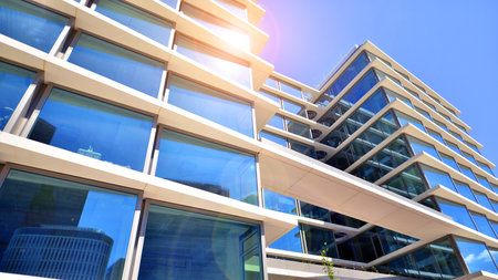 Downtown corporate business district architecture. Glass reflective office buildings against blue sky and sun light. Economy, finance, business activity concept. Abstract modern aの写真素材