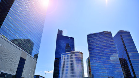 Downtown corporate business district architecture. Glass reflective office buildings against blue sky and sun light. Economy, finance, business activity concept. Abstract modern aの写真素材