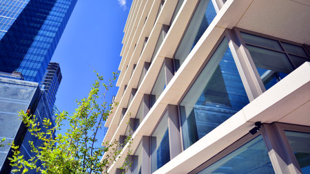 City life, urban landscape and ecology. Modern office complex with glass facades and smooth lines against backdrop of green trees, concept of modern architecture. Organically builtの写真素材