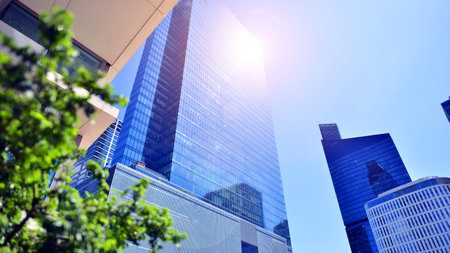 City life, urban landscape and ecology. Modern office complex with glass facades and smooth lines against backdrop of green trees, concept of modern architecture. Organically builtの写真素材