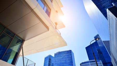 Downtown corporate business district architecture. Glass reflective office buildings against blue sky and sun light. Economy, finance, business activity concept. Abstract modern aの写真素材