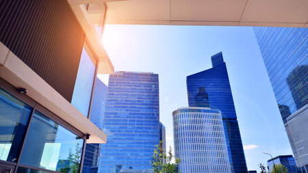 Downtown corporate business district architecture. Glass reflective office buildings against blue sky and sun light. Economy, finance, business activity concept. Abstract modern aの写真素材