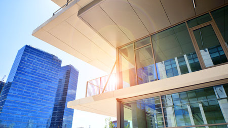 Downtown corporate business district architecture. Glass reflective office buildings against blue sky and sun light. Economy, finance, business activity concept. Abstract modern aの写真素材