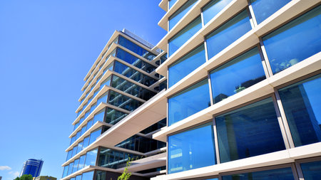 Downtown corporate business district architecture. Glass reflective office buildings against blue sky and sun light. Economy, finance, business activity concept. Abstract modern aの写真素材