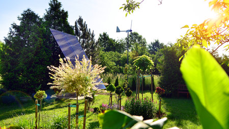 Solar panels with wind turbine on blue sky. Concept of clean energy. Green technology for the future.の写真素材