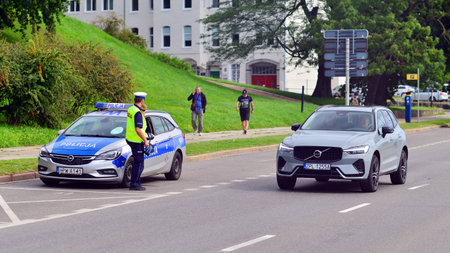 Szczecin, Poland. 16 July 2025. Traffic police officer holding a radar speed gun on street. Back...